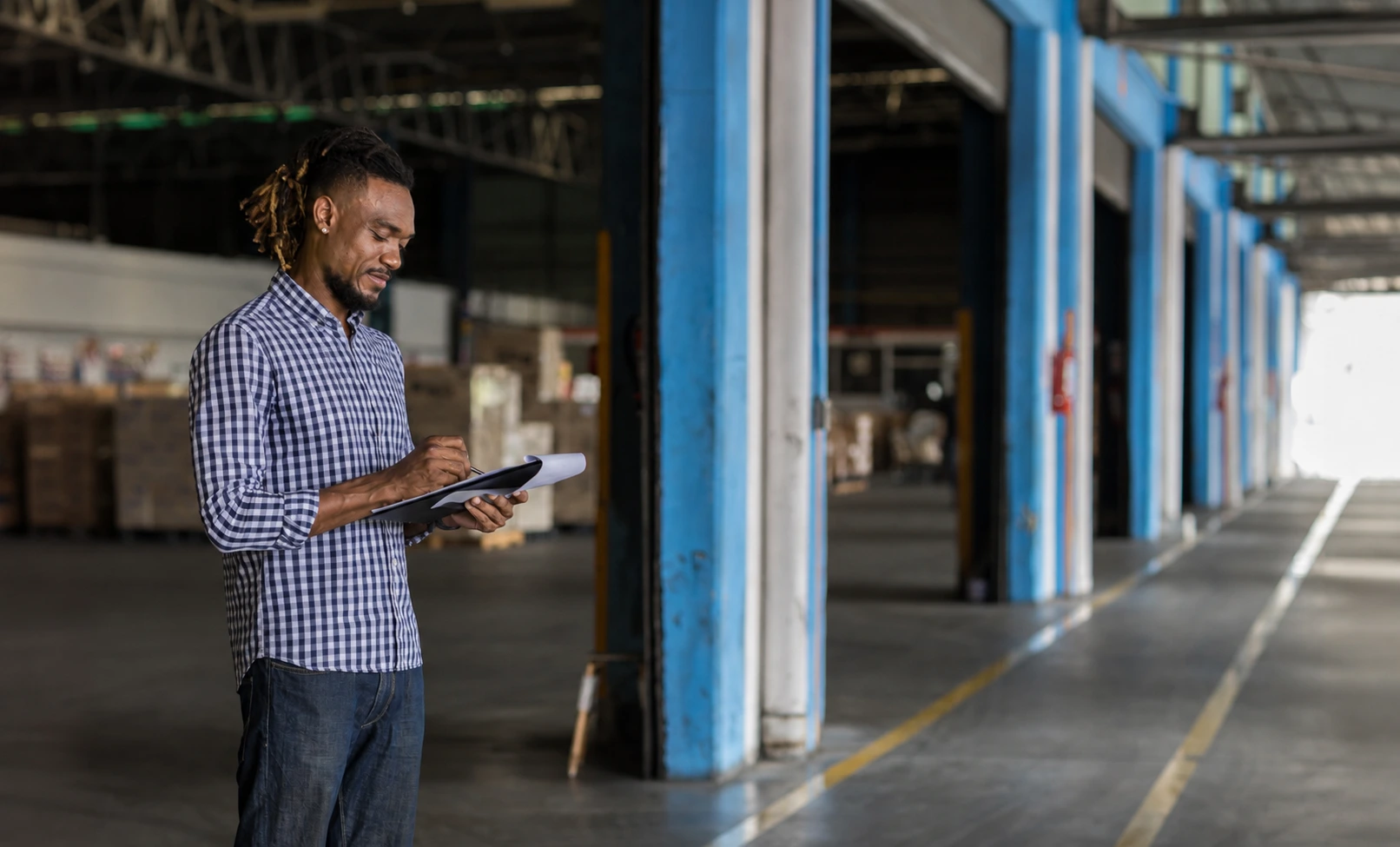 An environmental professional documents site conditions during an environmental site assessment of an industrial warehouse facility.
