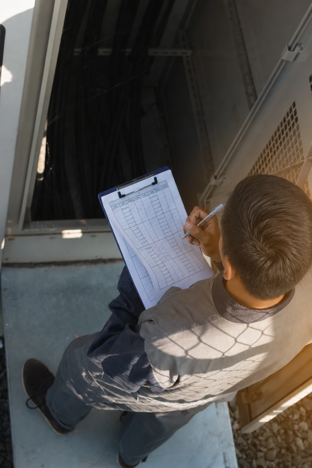 A property condition consultant documents the condition of building equipment during a commercial property inspection.